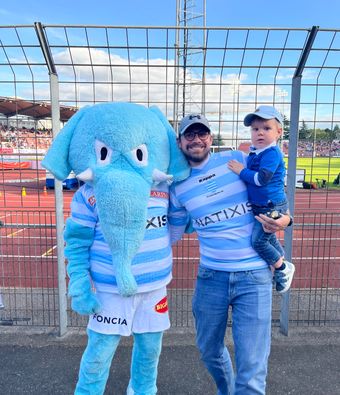 Un fan et son enfant posent avec la mascotte du Racing 92.